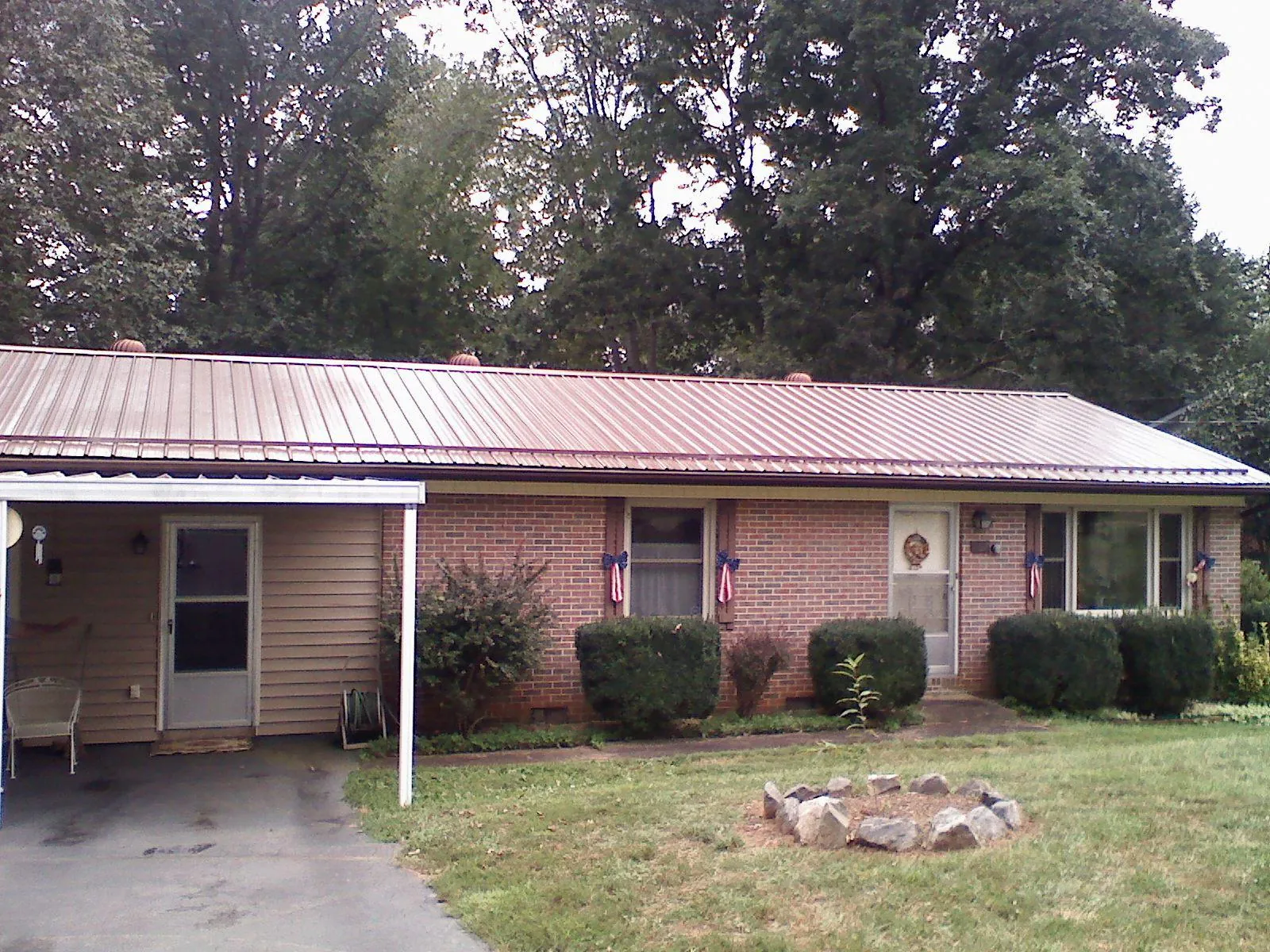 Bronze metal roof and carport on a brick ranch home — Roof Repair work by our crew in Coralville