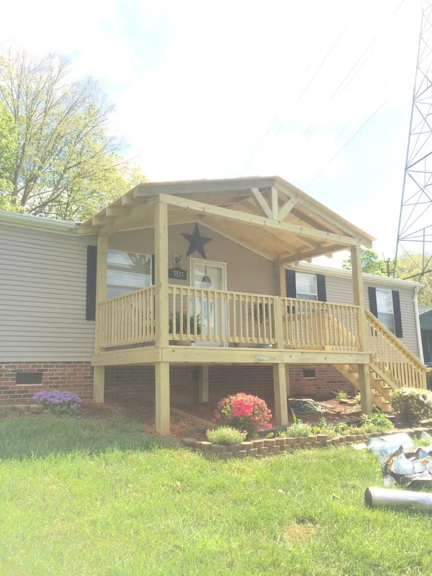 New gabled porch roof and deck railing added to a ranch home in Coralville